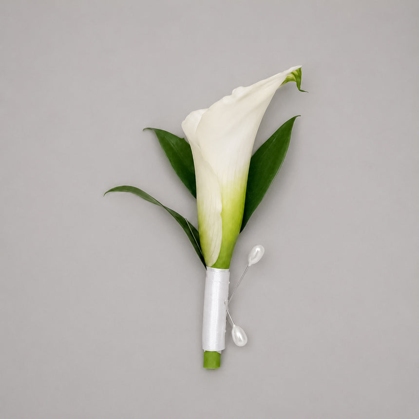 Devotion white calla lily boutonniere with white satin ribbon