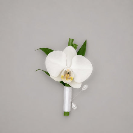 Élan white orchid boutonniere with white satin ribbon and pearl pins