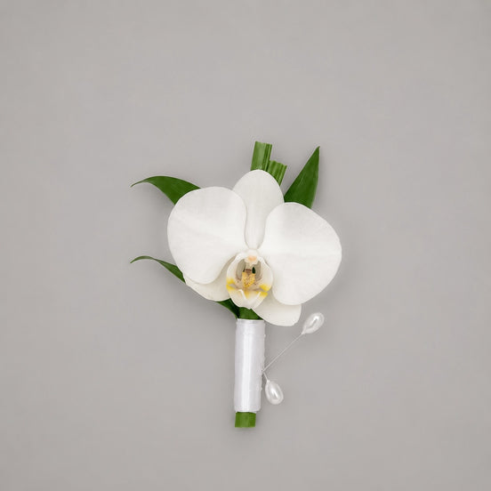 Élan white orchid boutonniere with white satin ribbon and pearl pins